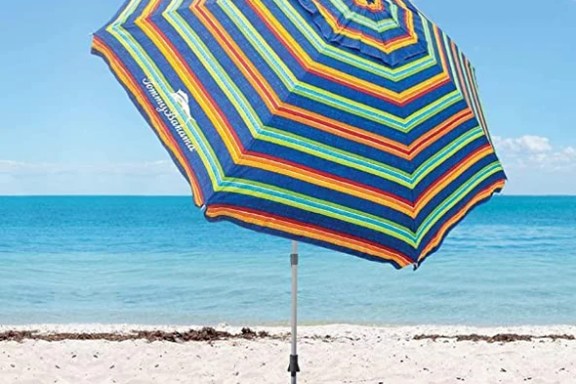 a colorful umbrella sitting on top of a sandy beach